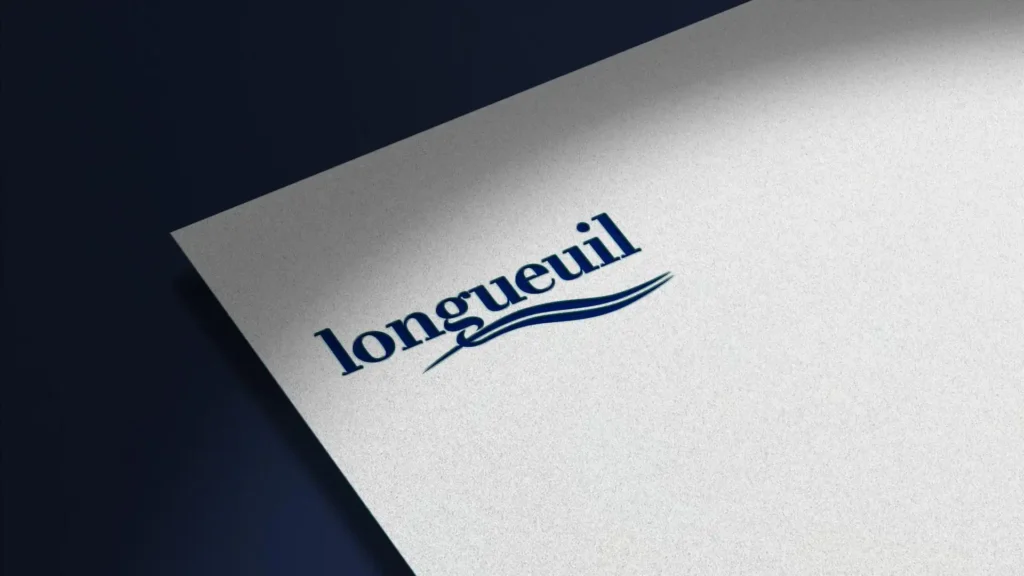 Gros plan d'une feuille de papier blanc texturé, inclinée, avec le mot "longueuil" écrit en bleu marine, accompagné de deux traits stylisés en dessous.