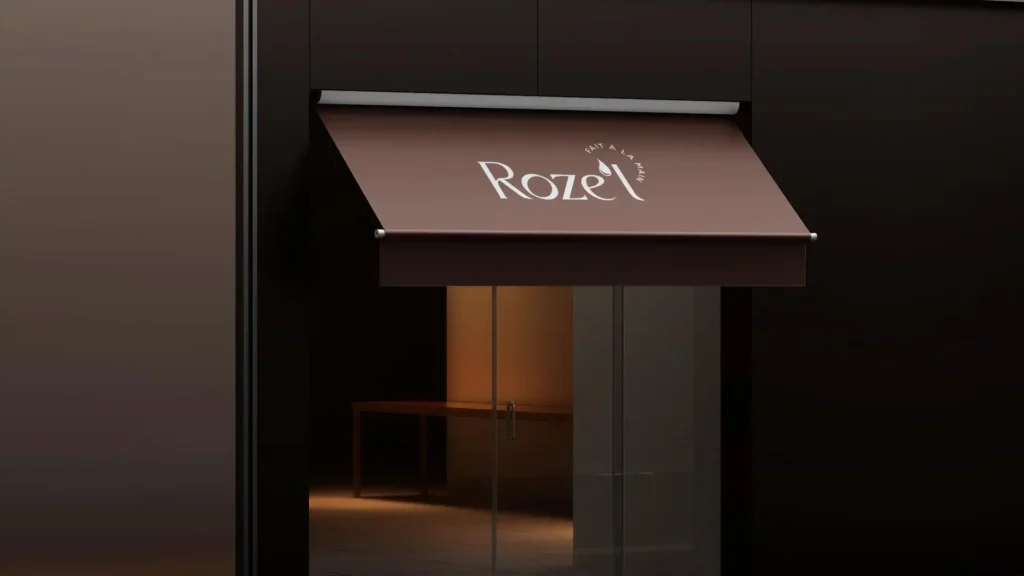 Un auvent brun foncé avec le mot "Roze'L" écrit en blanc au-dessus d'une entrée vitrée.